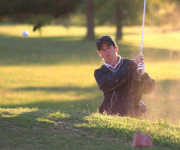 Lady hitting out of sand bunker