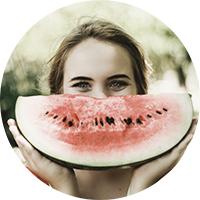Lady holding up watermelon slice