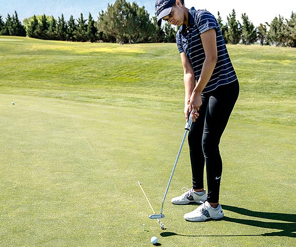 Young girl practicing on putting green