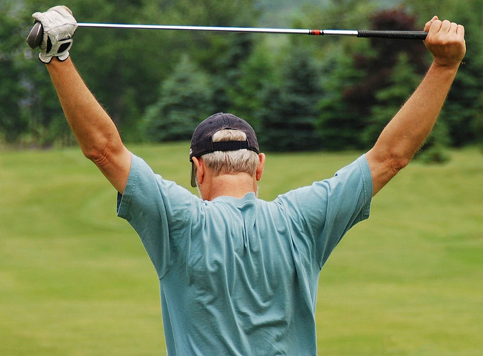 Back view of golfer stretching arms